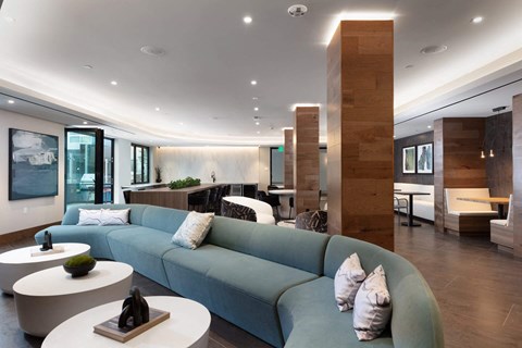 a large living room with a blue couch and tables