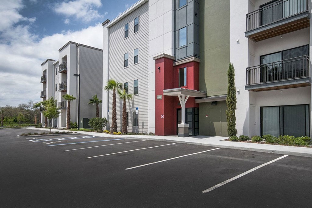 an empty parking lot in front of some apartment buildings