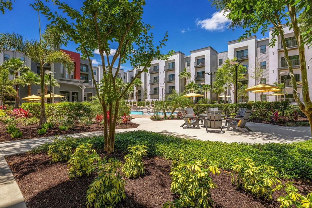 a courtyard with a table and chairs in front of an apartment building
