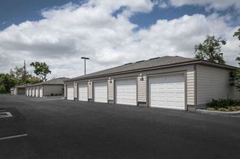 a row of garages with white doors and a cloudy sky