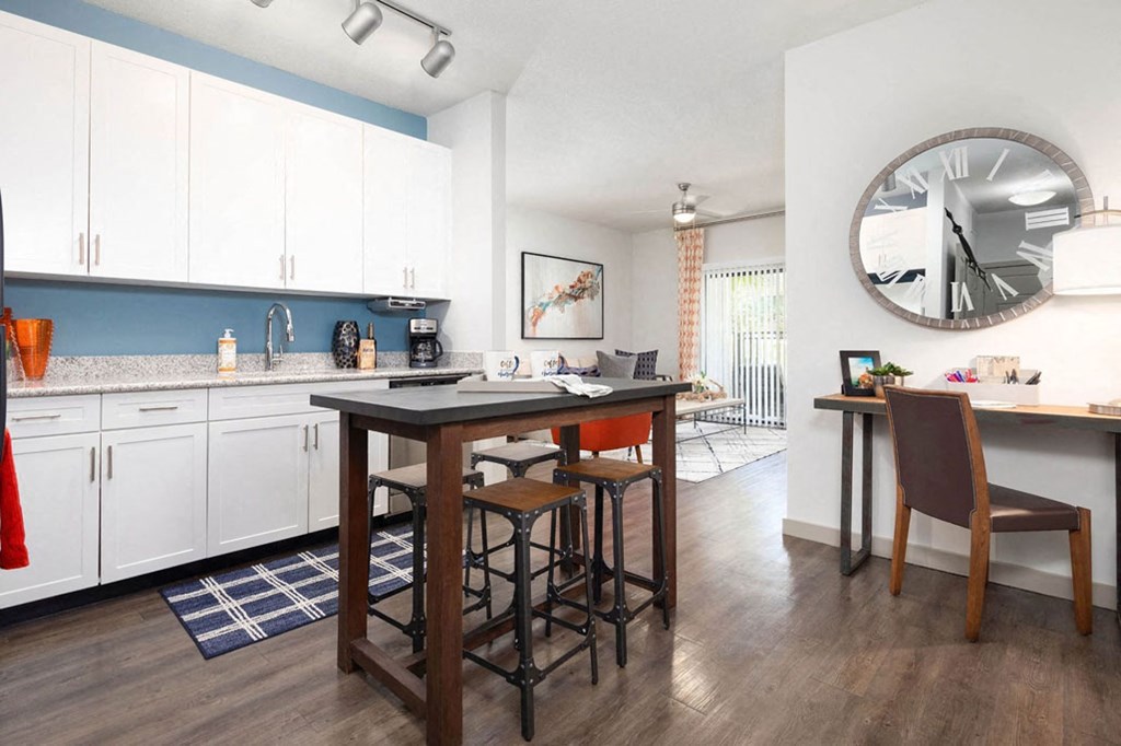 a kitchen and dining room with a large clock on the wall