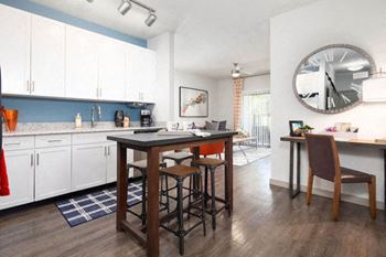 a kitchen and dining room with a large clock on the wall
