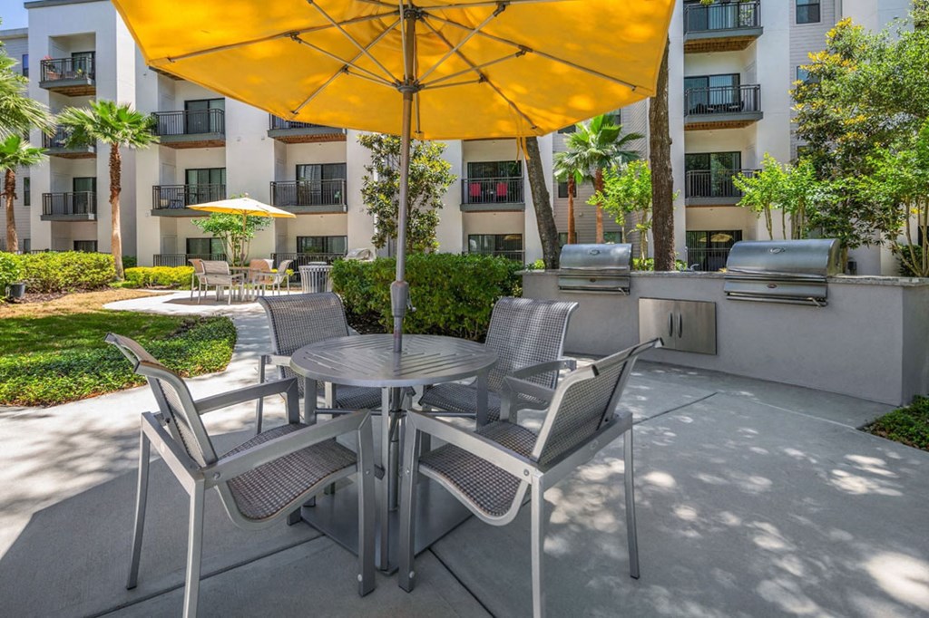 a patio with a table and chairs under an umbrella
