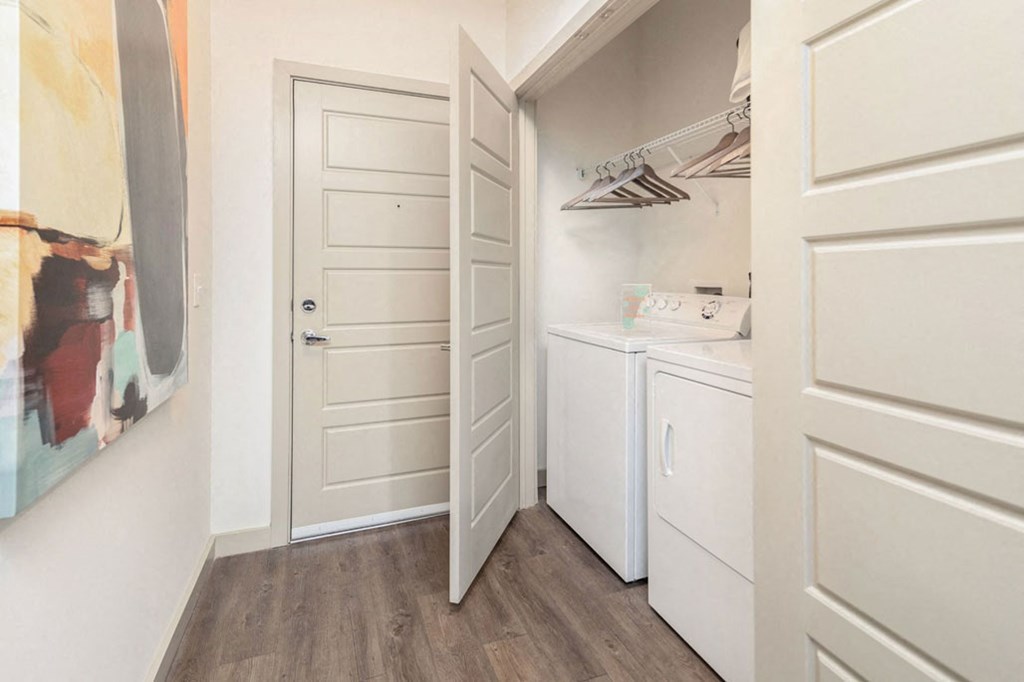 a small kitchen with white appliances and a door to a closet