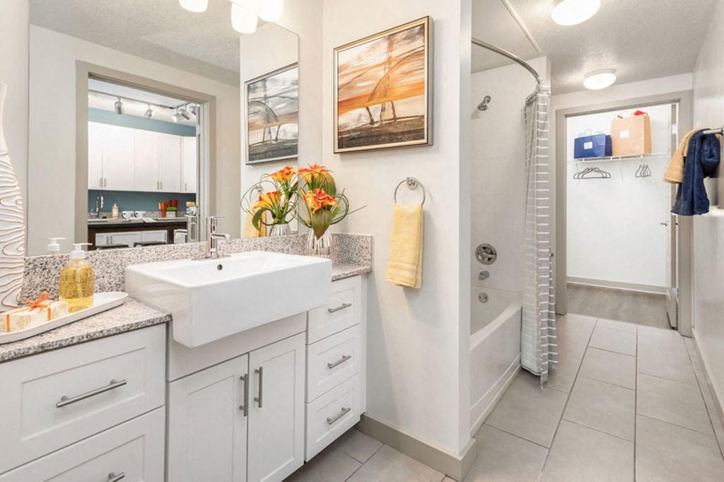 a white bathroom with a sink and a shower