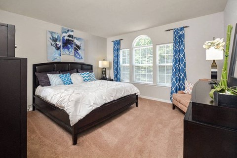 a bedroom with a bed and a large window