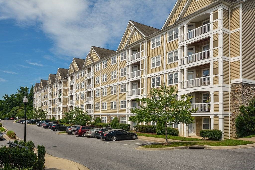 a large apartment building with cars parked in front of it