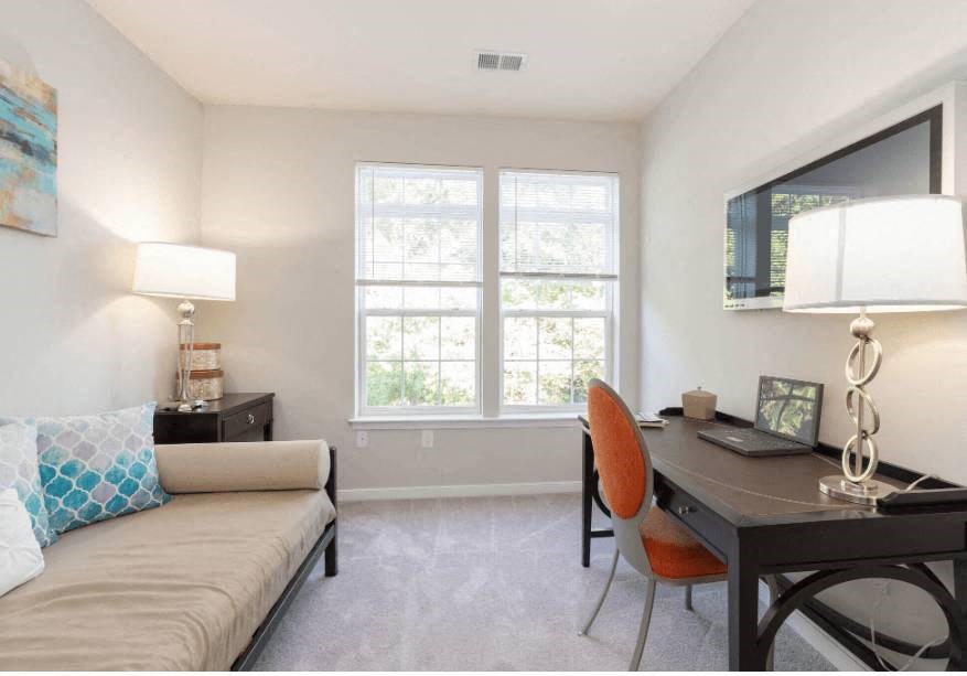 a living room with a desk and a couch