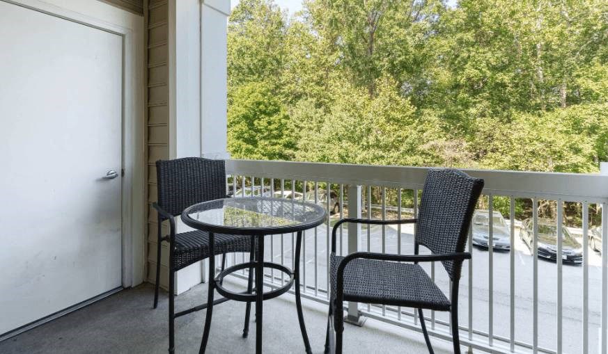 a patio with two chairs and a table on a balcony