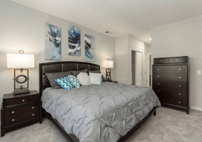 a bedroom with a bed and two dressers