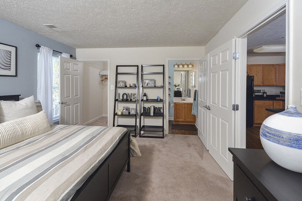 a bedroom with a bed and a closet and a bathroom