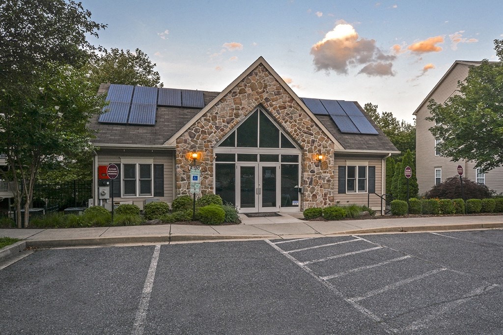 the front of a building with solar panels on the roof