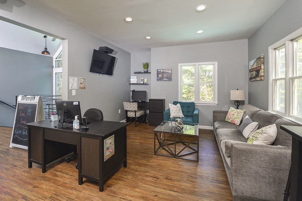 a living room with a couch and a desk and a tv
