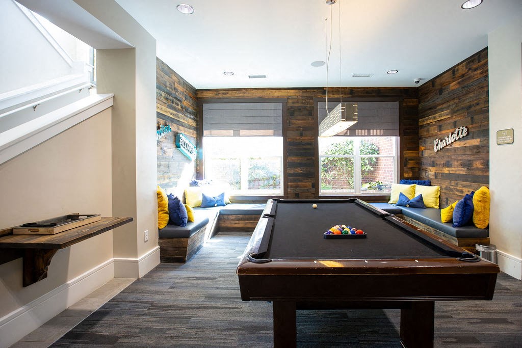 a games room with a pool table and a window