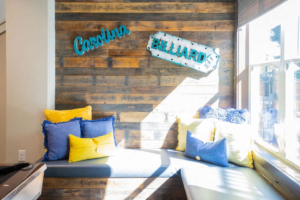 a seating area with pillows and a reclaimed wood wall