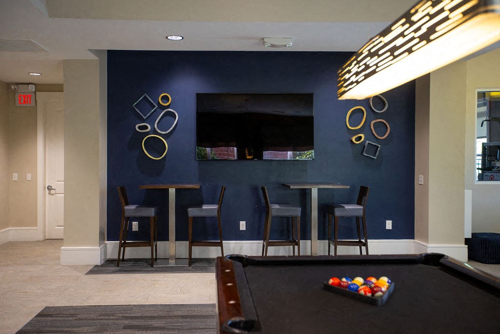 a game room with a pool table and a tv