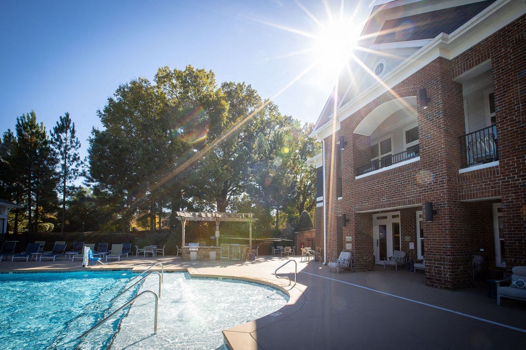 the sun shining over the pool at the resort on a sunny day
