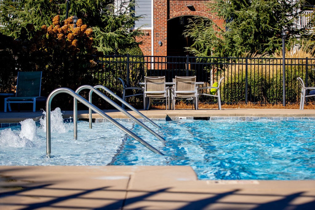 a swimming pool with a metal in front of chairs