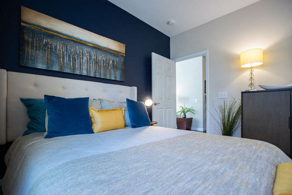 a bedroom with a bed and a painting on the wall