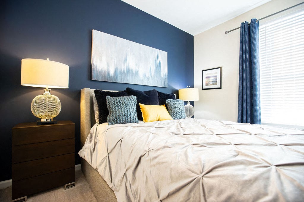 a bedroom with a bed and a painting on the wall