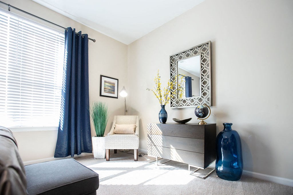 a living room with a dresser and a mirror