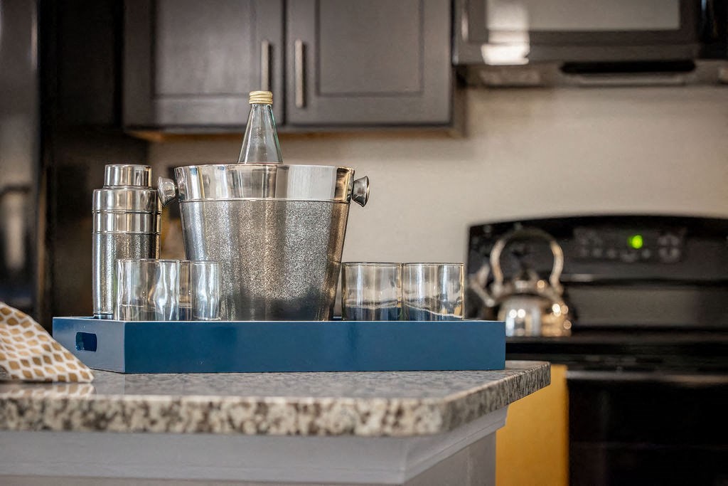 a kitchen counter with glasses and a container on it