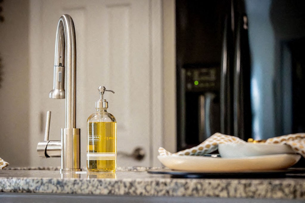 a kitchen counter with a bottle of soap and a sink