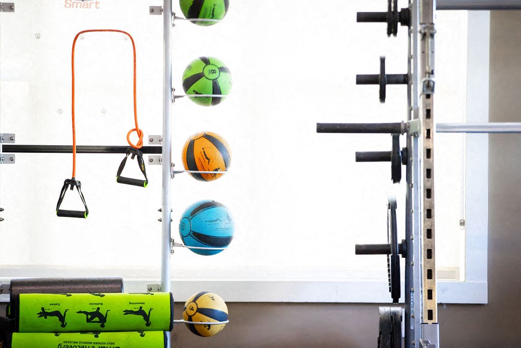a wall in a gym with weights and balls