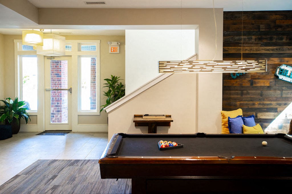 a game room with a pool table and a window