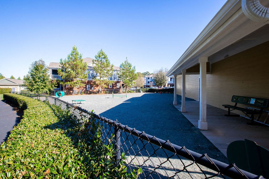 a patio with a chain link fence and a playground