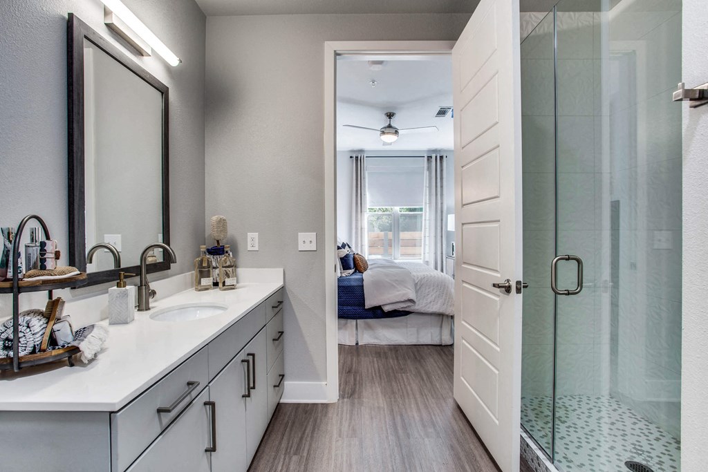 a bathroom with a shower and a sink and a mirror