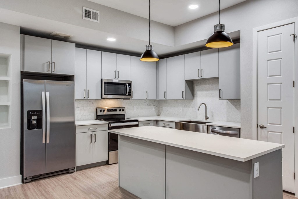 a kitchen with white cabinets and stainless steel appliances
