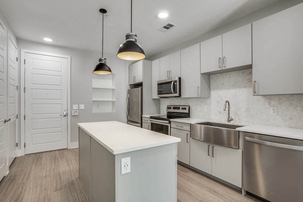 a kitchen with white cabinets and stainless steel appliances