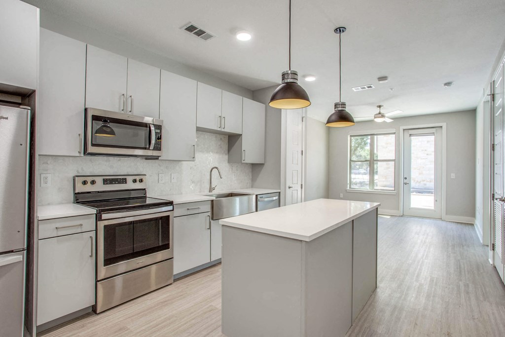 a kitchen with white cabinets and stainless steel appliances