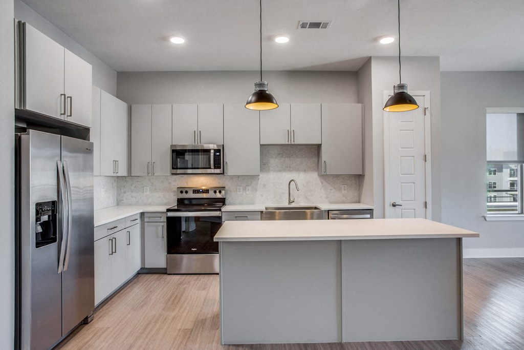 a kitchen with white cabinets and stainless steel appliances