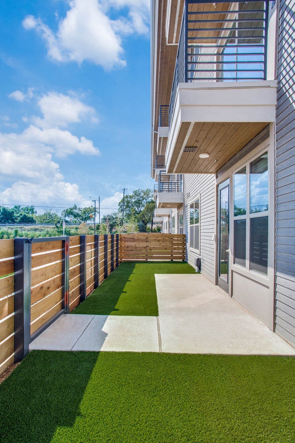 the patio of a home with a view of the yard and a balcony