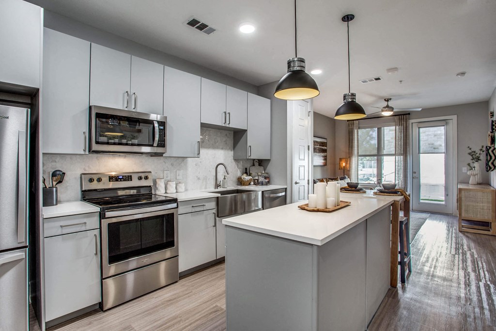 a kitchen with white cabinets and stainless steel appliances