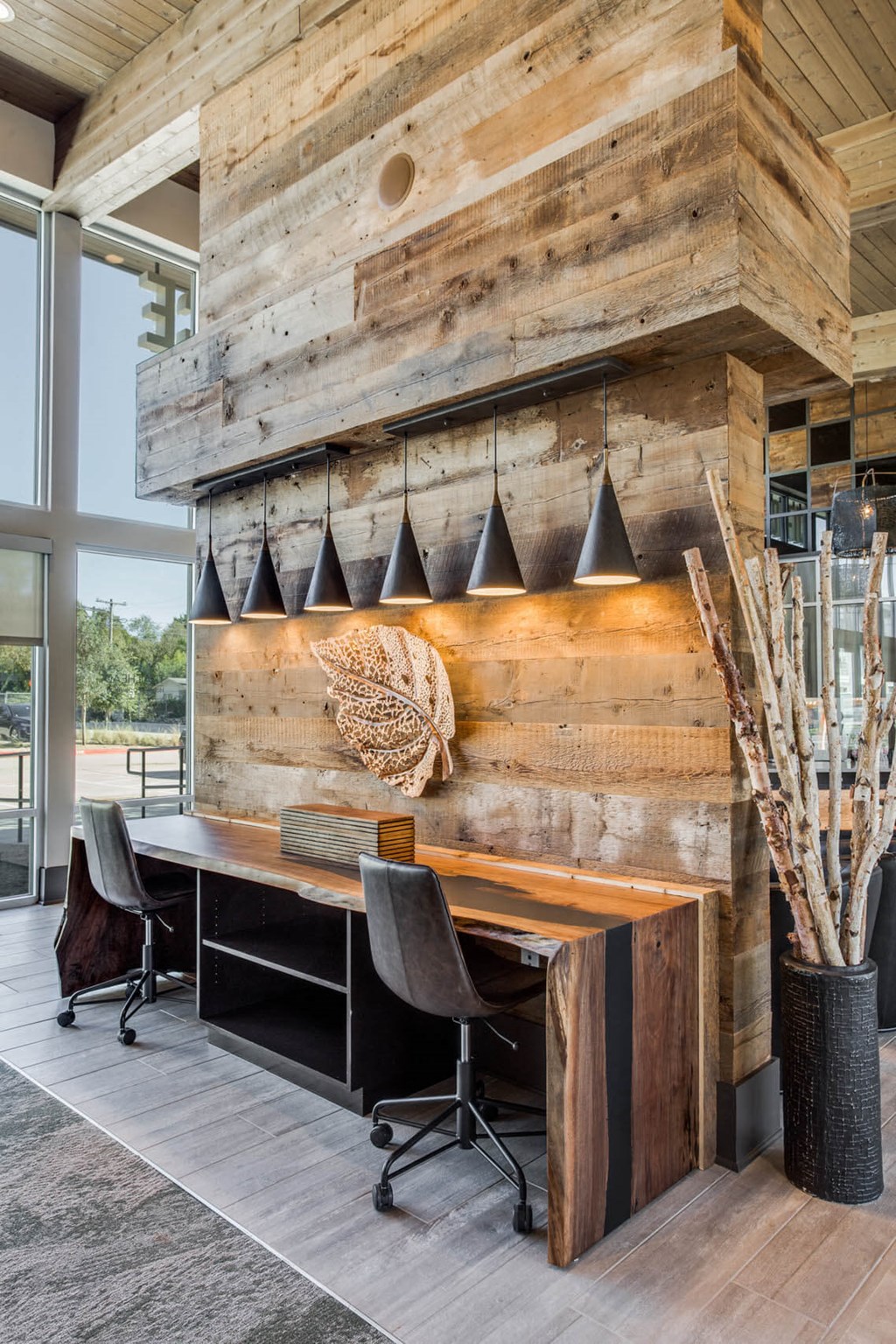 a conference room with a wooden wall and a desk with chairs