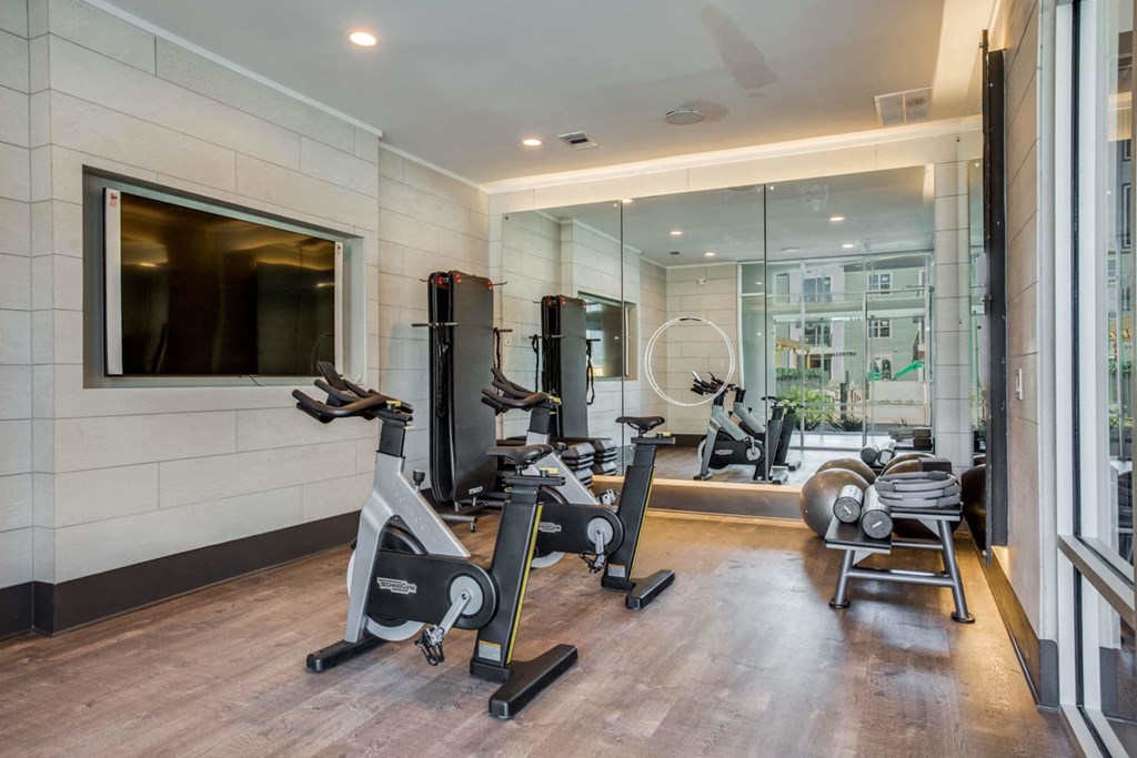 a gym with treadmills and exercise equipment in a room with a large window