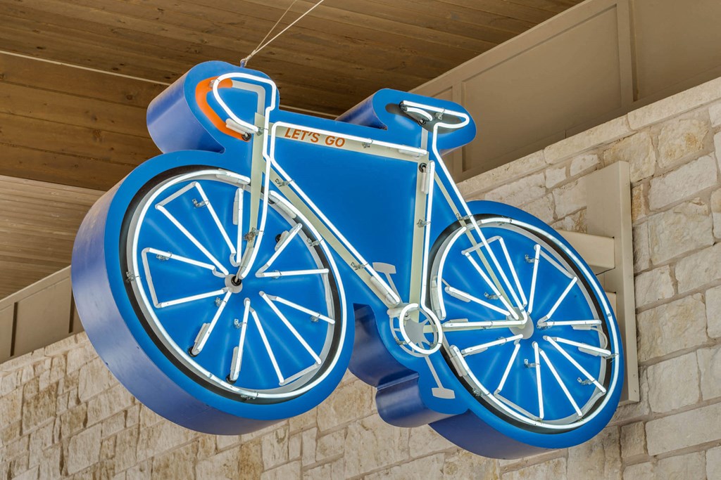 a blue bicycle sign hanging from the side of a building