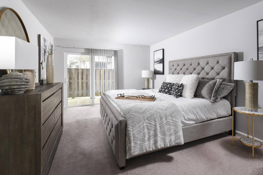 a bedroom with a bed and a dresser and a window