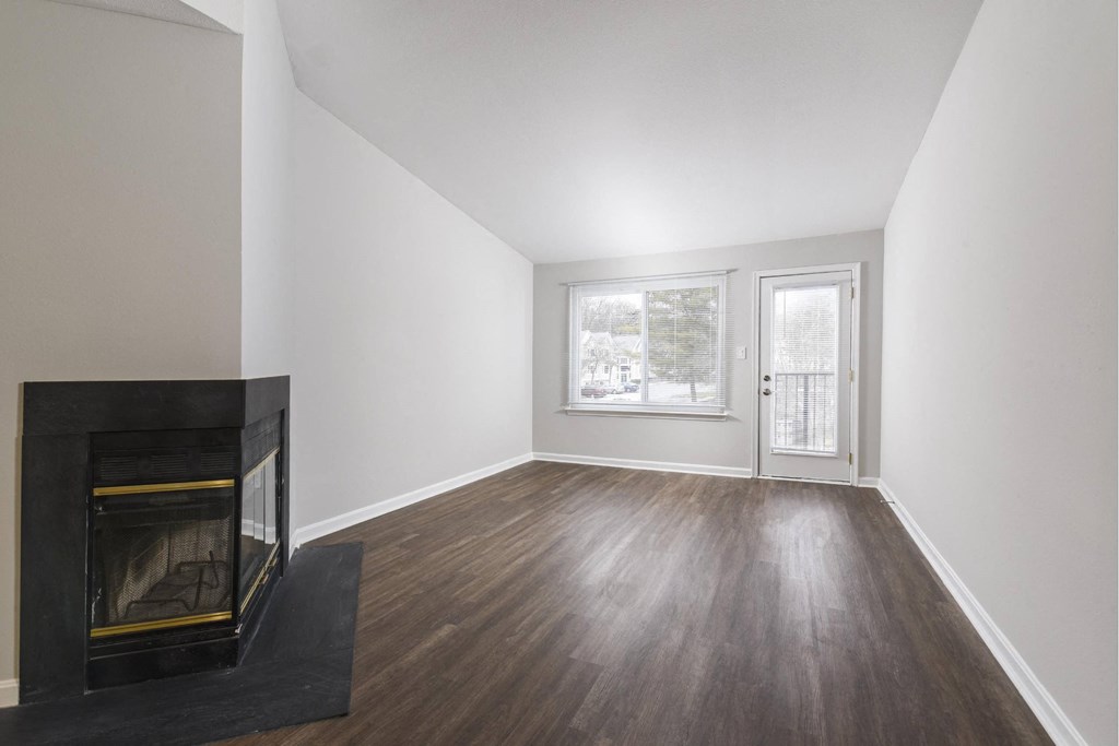 a living room with a fireplace and a door to a balcony