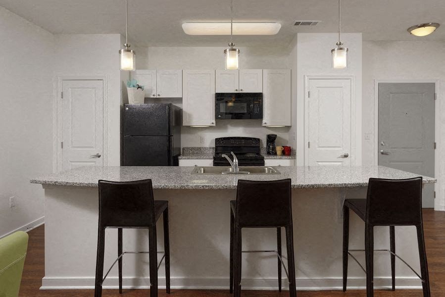 a kitchen with a counter and three bar stools