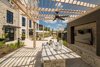 a patio with a pergola and a fireplace