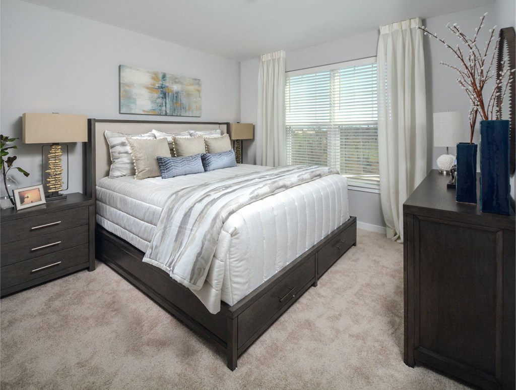 a bedroom with a bed and a dresser and a window