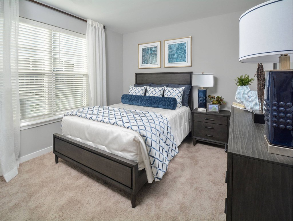 a bedroom with a bed and a large window