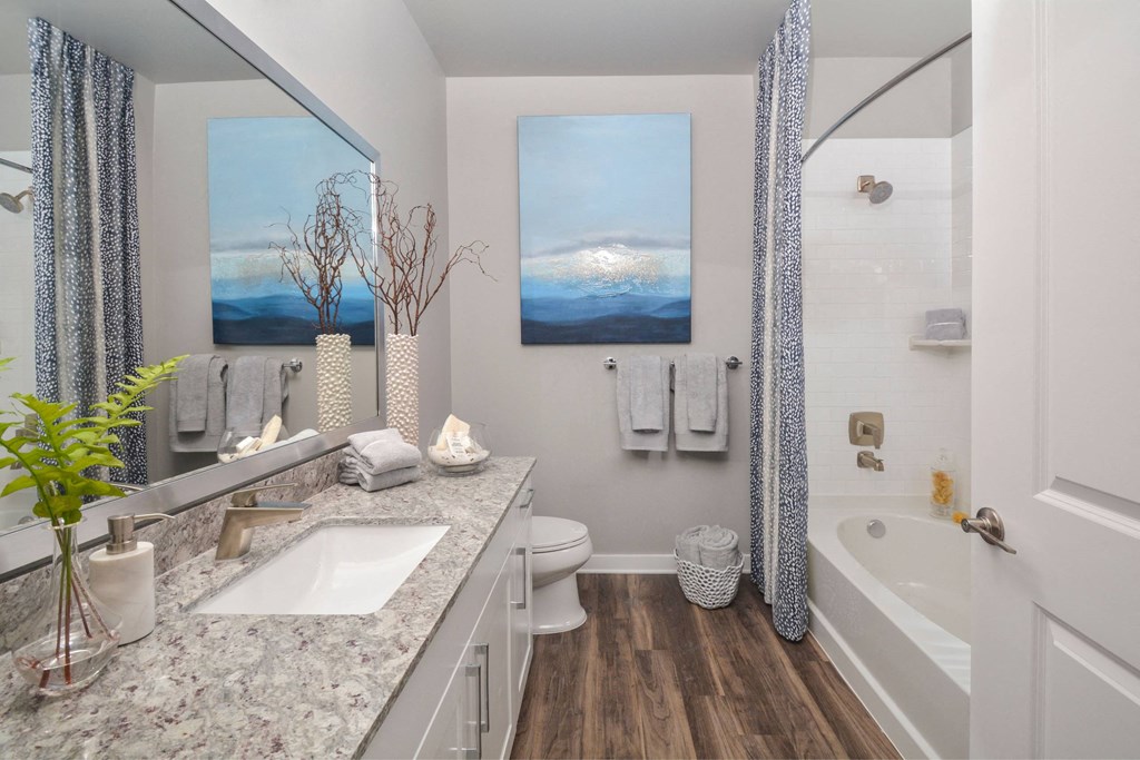 a bathroom with a large mirror and a tub and a sink