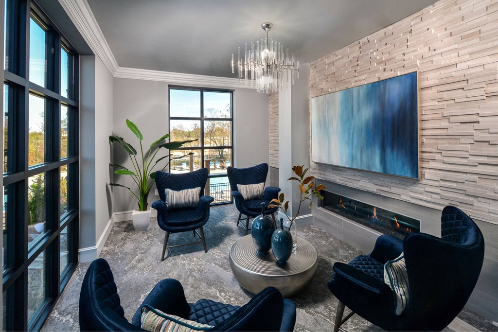 a living room with blue chairs and a fireplace