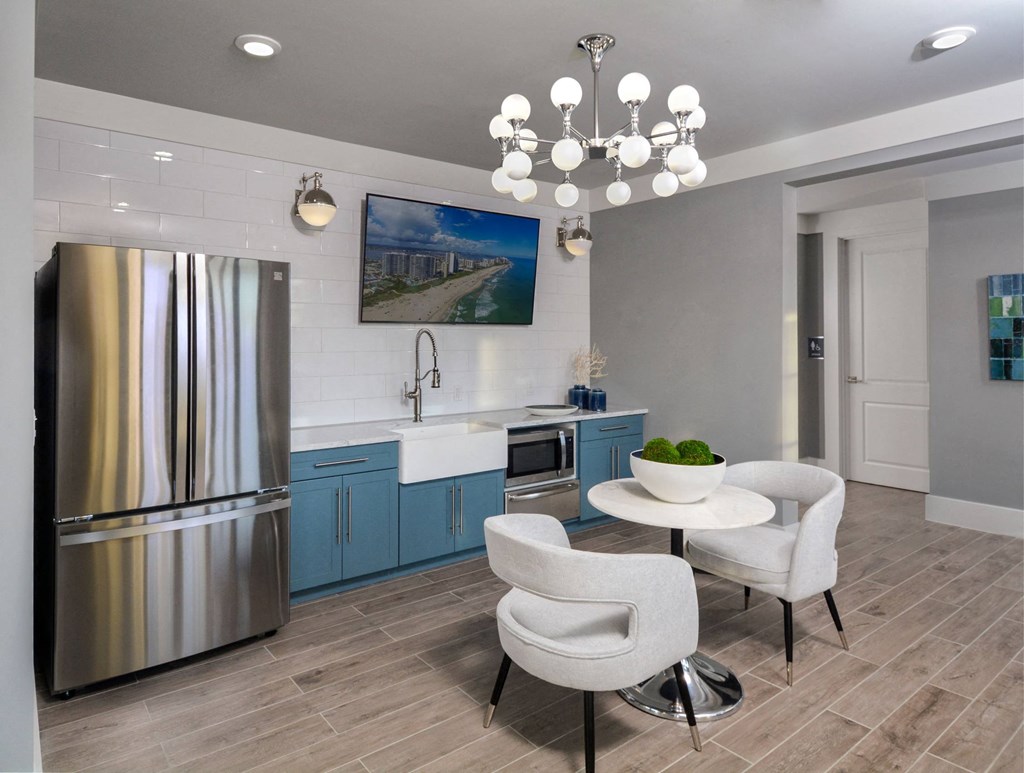 a kitchen with a stainless steel refrigerator and a table and chairs