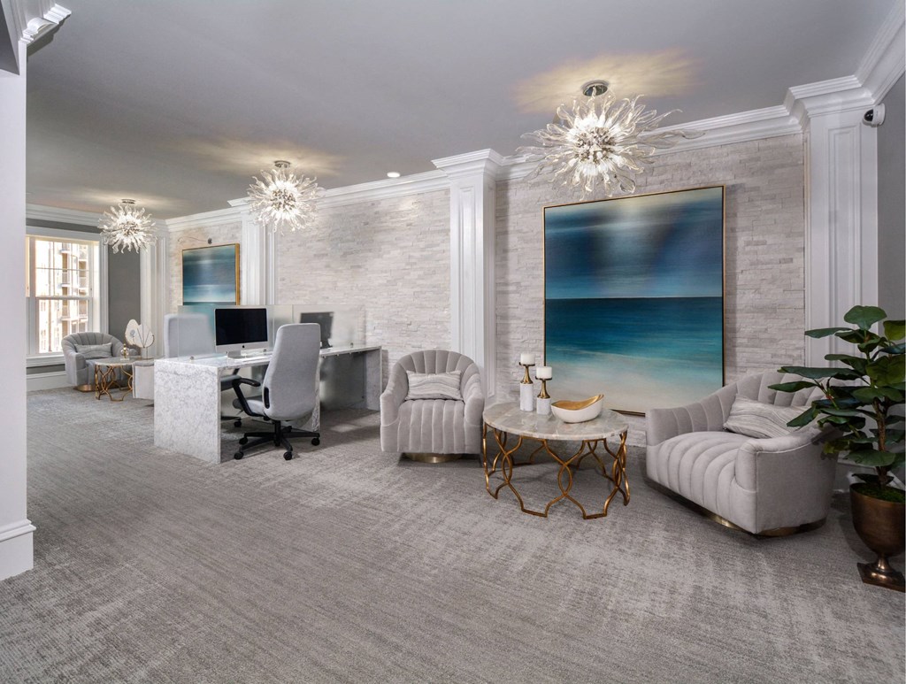 a living room with white furniture and a large painting on the wall